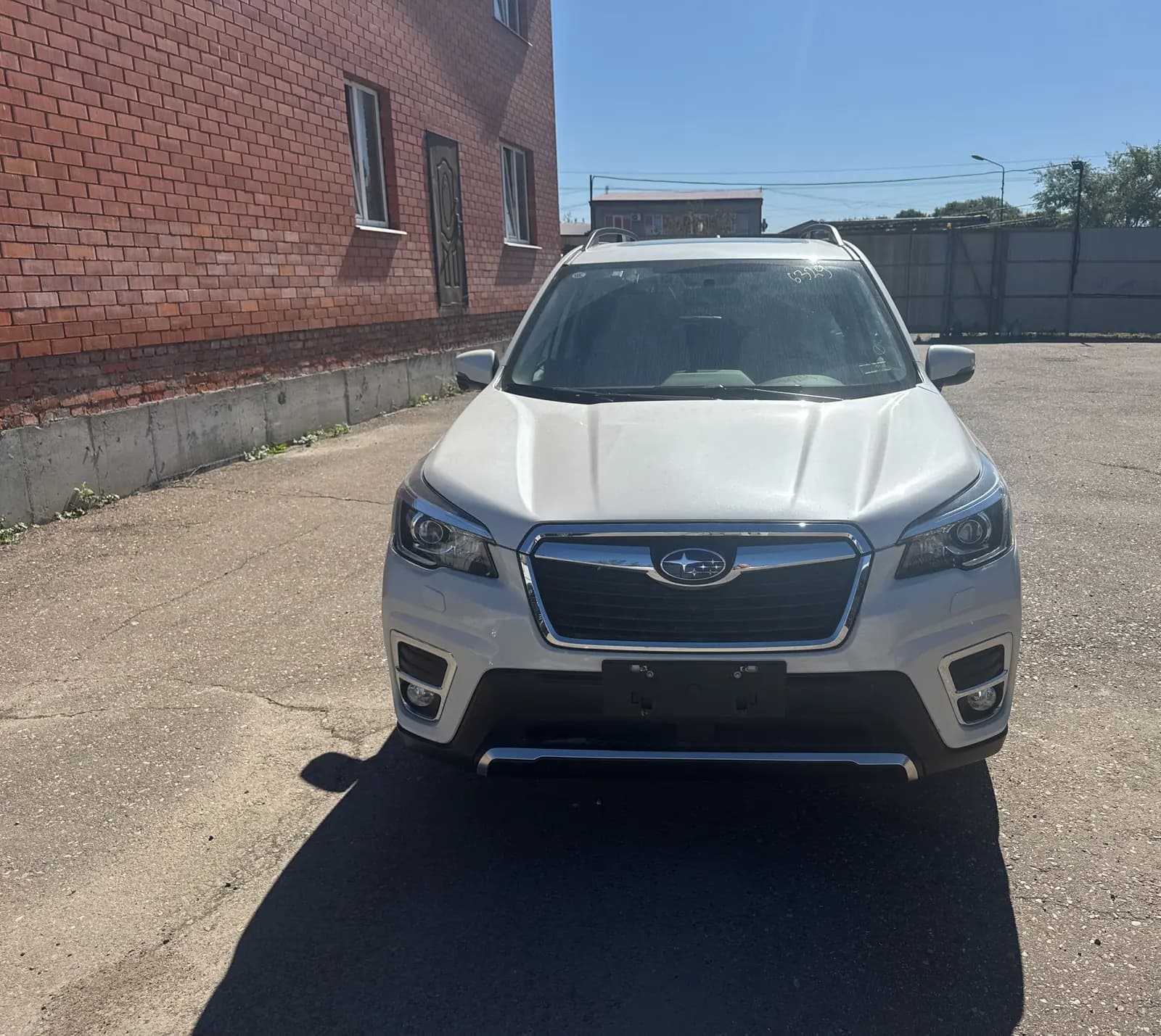 Subaru Forester спереди на площадке у кирпичного здания